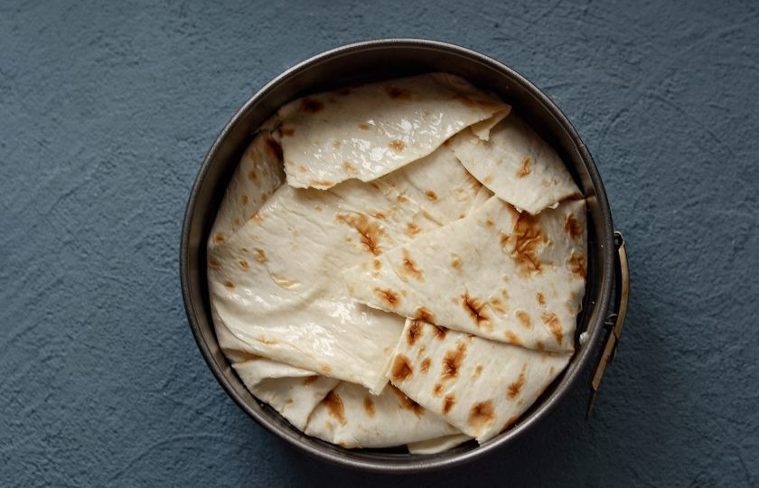 1. Этап. Пирог из лаваша с кабачками: Заверните края лаваша так, чтобы он полностью покрывал диаметр формы для выпечки, лишнее отрежьте. Смажьте верхушку растительным маслом. Выпекайте пирог в духовке 30-35 минут при температуре 170 градусов.