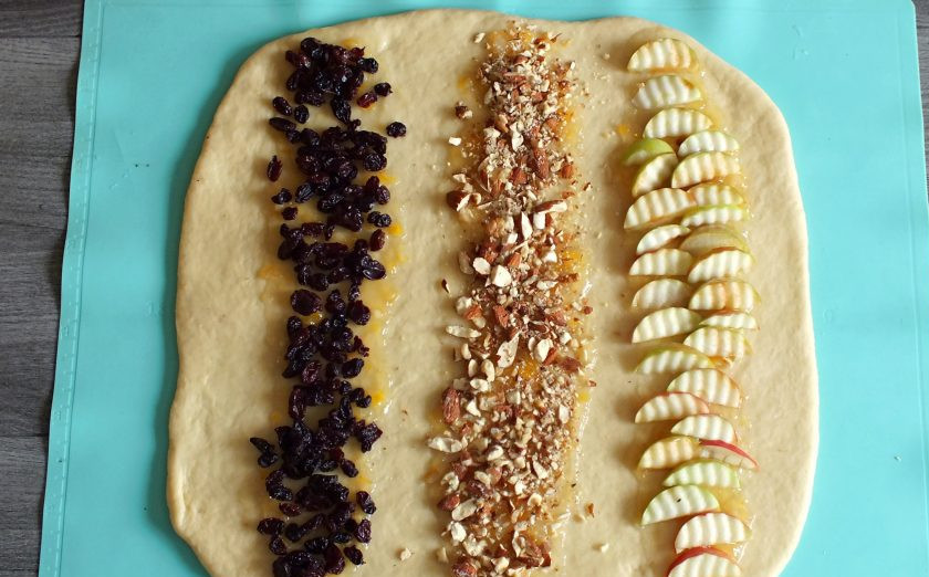 1. Этап. Дрожжевой пирог с яблоками и изюмом: На полосы из варенья выложите нарезанные яблоки, дробленые орехи и изюм. Изюм заранее вымойте и хорошо просушите.