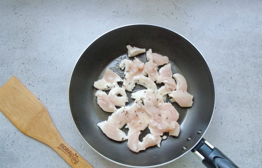 1. Этап. Салат Лада: Куриное филе помойте и нарежьте. Выложите в сковороду с подсолнечным маслом. Посыпьте любимой приправой, у меня это сушеный базилик.