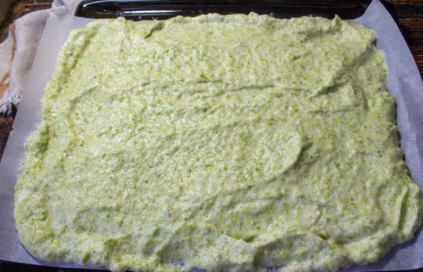 1. Этап. Рулет из брокколи с творожным сыром: Полученную массу переложите ровным слоем на противень, выстеленный пергаментом с силиконовым покрытием. Если вы не уверены в качестве своего пергамента, то смажьте тонким слоем растительного масла. Выпекайте в разогретой духовку до 180 градусов 12-15 минут.