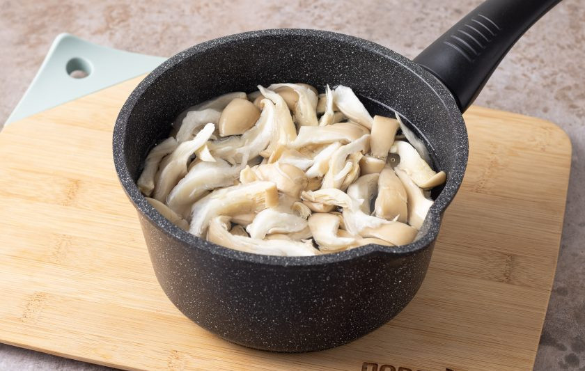 1. Этап. Корейский салат с грибами: Опустите в кипящую воду и отварите 3 минуты. Затем откиньте на сито и отожмите от лишней влаги.