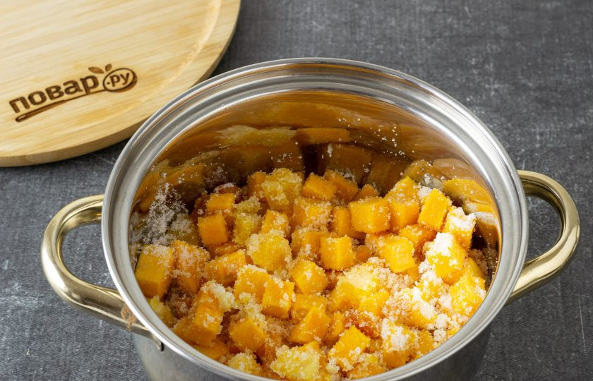1. Этап. Варенье из тыквы с апельсином и курагой: Переложите в кастрюлю тыкву, курагу и апельсин. Добавьте сахар, перемешайте и оставьте на 2-3 часа, чтобы тыква пустила сок.