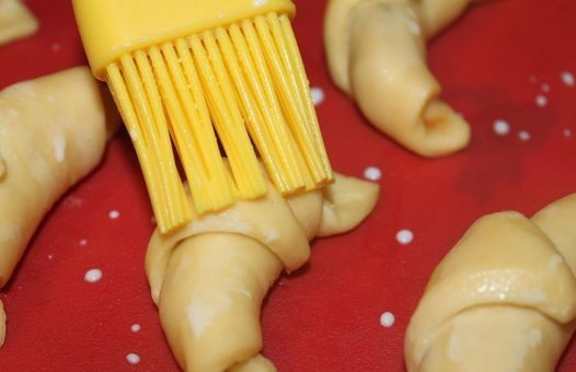 1. Этап. Дрожжевые рогалики: Смазываем рогалики с помощью кисточки молоком или сладкой водой.