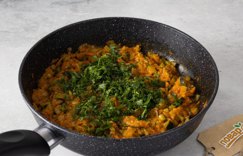 1. Этап. Икра из цукини: Зелень мелко порубите. Добавьте в сковороду. Все перемешайте. Накройте сковороду крышкой и дайте икре немного настояться.