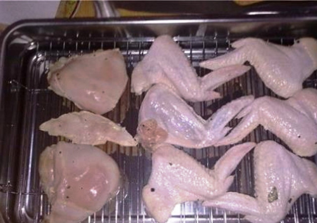 1. Этап. Крылышки в коптильне: Маринованные крылышки слегка просушите с помощью бумажного полотенца и разложите на решетке коптильни. Насыпьте на дно ольховых опилок, закройте крышку и поставьте на огонь.