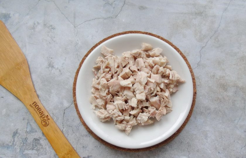 1. Этап. Слоеный салат Граф с курицей, свеклой и черносливом: Отварное куриное филе нарежьте кубиками.