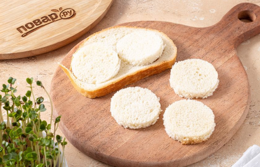 1. Этап. Канапе с огурцом и сыром: Из хлеба с помощью формочки вырежьте небольшие кружки или просто нарежьте его на квадратики.