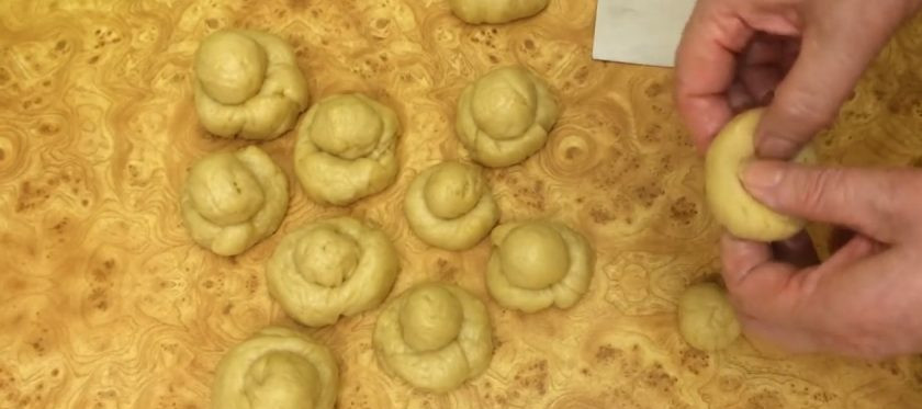 1. Этап. Булочки Бриошь на закваске: 6. Сформируйте булочки: от шарика отделите 1/3 часть, скатайте в шарик и поместите в предварительно сделанное отверстие в большом шарике. Выложите булочки в форму для выпечки.