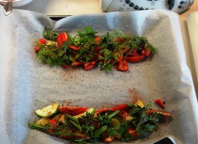 1. Этап. Запеченная рыба: Цуккини, перец и помидор нарежьте и выложите на застеленный пергаментом противень. Распределите овощи по краям противня и посыпьте их измельченной зеленью. Посолите, поперчите и полейте уксусом.