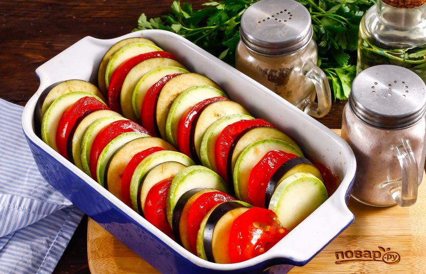 1. Этап. Рататуй в микроволновке: Точно также нарежьте оставшиеся помидоры, промыв их в воде и вырезав зеленые сердцевинки. Выложите в форму прямо в соус кружочки овощей, чередуя их друг за другом.