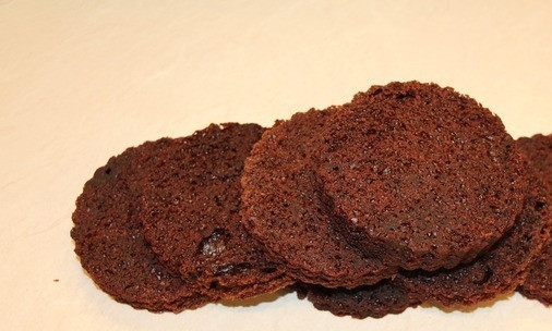 1. Этап. Пирожное Вишнёвый ноктюрн: Остывший бисквит разрежьте на 4 части по ширине. Круглой формочкой вырежьте небольшие круги (диаметр с кружку).