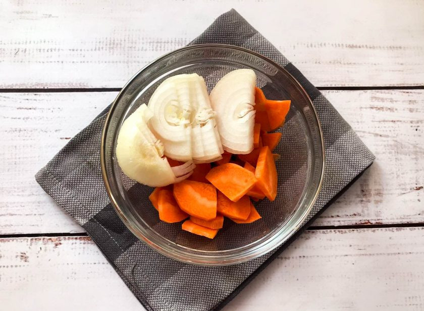 1. Этап. Селедка в духовке в рукаве: Лук очистите от шелухи и нарежьте полукольцами. Морковь хорошо помойте, почистите и крупно нарежьте.