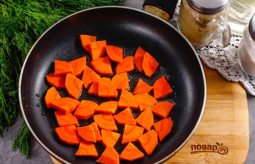 1. Этап. Теплый салат с куриными сердечками: Морковь и лук очистите от кожуры, промойте в воде вместе с кабачком, у кабачка срежьте хвостики. Морковь нарежьте крупными кусочками и обжарьте в 1 ст.л. растительного масла на сковороде, примерно 2-3 минуты до румяности и небольшой мягкости. Выложите на тарелку.