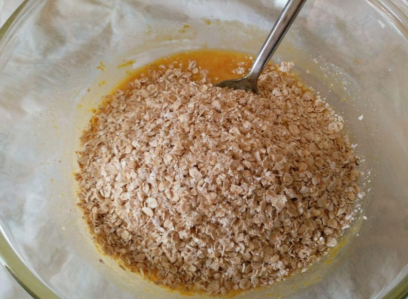 1. Этап. Яблочный пирог из овсяного теста: Всыпьте овсяные хлопья в жидкую основу и тщательно перемешайте получившееся тесто.