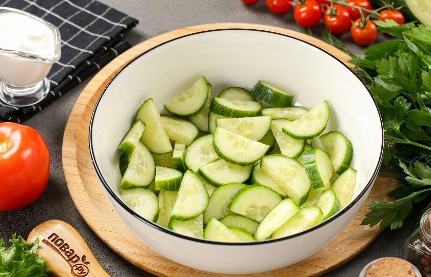 1. Этап. Салат из помидоров и огурцов со сметаной: Огурцы промойте, срежьте кончики и нарежьте полукольцами или кружочками, как вам больше нравится.