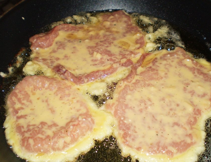 1. Этап. Свинина (отбивная, жаренная на сковороде в кляре): 6. Обмакиваем отбивные с обеих сторон в кляре и отправляем на сковороду. Жарим их на растительном масле на среднем огне с двух сторон до красивой коричневой корочки.