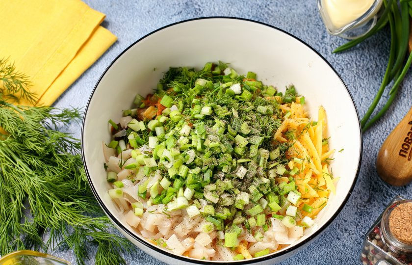 1. Этап. Кальмары фаршированные грибами на сковороде: Соедините содержимое сковороды и измельчённые плавники кальмаров. Добавьте тёртый сыр и любую свежую зелень. Посолите и поперчите начинку по вкусу.