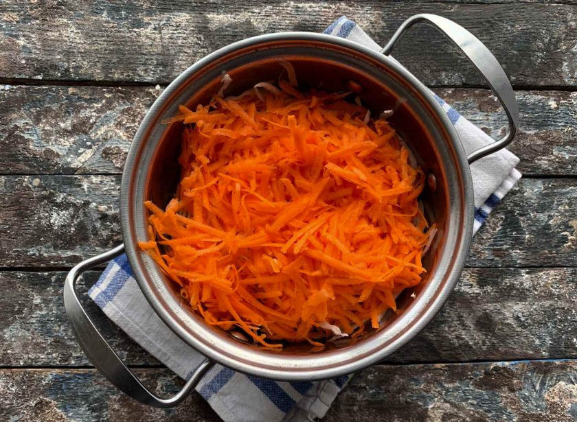 1. Этап. Квашеная капуста с изюмом: Морковь натрите на мелкой терке и добавьте к капусте.