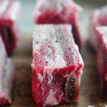 1. Этап. Рёбрышки в томатном соусе: Посыпать их солью и перцем.