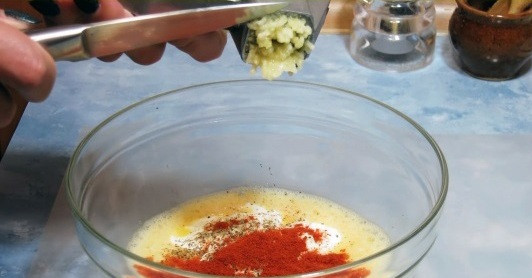 1. Этап. Домашние чипсы из лаваша: 3. Добавляем в яичную массу сушеную паприку (можно любые приправы по желанию и по вкусу), а также выдавливаем зубчик (два) чеснока. Все хорошенько перемешиваем.