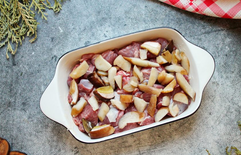 1. Этап. Индейка с белыми грибами: У белых грибов срежьте места загрязнения, почистите, сполосните и порежьте на дольки. Разложите грибы поверх индейки.