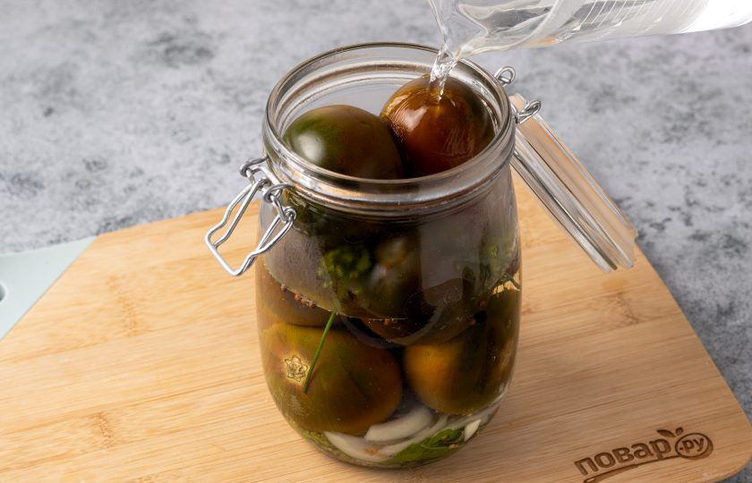 1. Этап. Черные помидоры в банках на зиму: Влейте в банку горячую воду. Прикройте банку крышкой и оставьте на 10 минут.