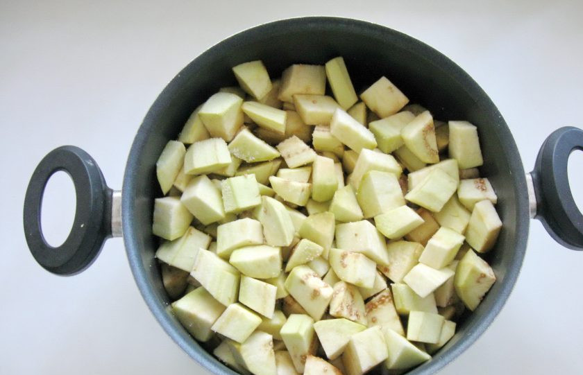 1. Этап. Закуска из баклажанов с помидорами на зиму: Выложите нарезанные баклажаны в кастрюлю. Посыпьте двумя чайными ложками соли и перемешайте. Дайте постоять 20 минут. После слейте образовавшуюся жидкость.