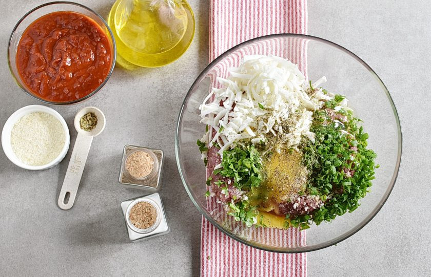 1. Этап. Итальянский ужин: Смешайте в глубокой миске фарш с хлебными крошками, тертой моцареллой, луком и петрушкой. Добавьте яйцо, посолите и поперчите по вкусу.