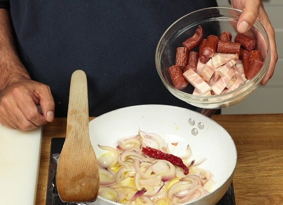 1. Этап. Фейжоада: В отдельной сковороде в масле обжарить нарезанные лук, чеснок, перец чили бекон, сало и копченую колбасу.
