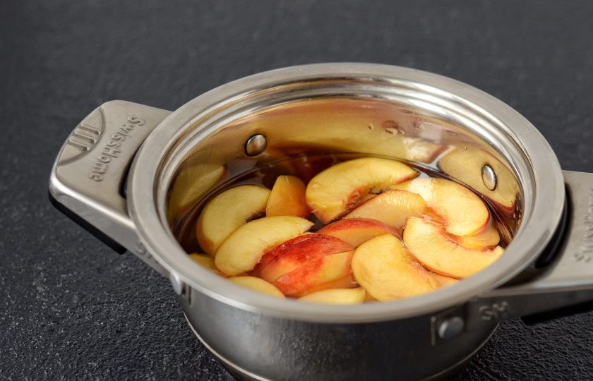 1. Этап. Персиковый чай: Нарежьте персики, добавьте в кастрюлю 200 мл. воды и сахар. Доведите до кипения и варите сироп 10-15 минут.