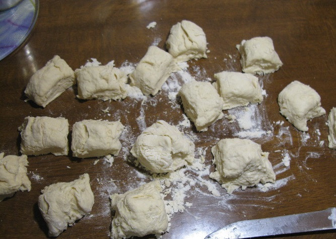 1. Этап. Лепешки на сковороде: 1. Рецепт приготовления лепешки на сковороде весьма прост. Сначала необходимо замесить тесто. Для этого нужно смешать 2 стакана муки, соль, сахар, соду и яйцо. Затем добавить кефир и тщательно перемешать. Постепенно добавлять муку, если понадобится, чтобы вымешать достаточно крутое тесто. Тесто должно получится эластичным и мягким, при этом может слегка прилипать к рукам. Необходимо разделить тесто на порции (можно скатать его трубочкой и аккуратно порезать ножом).