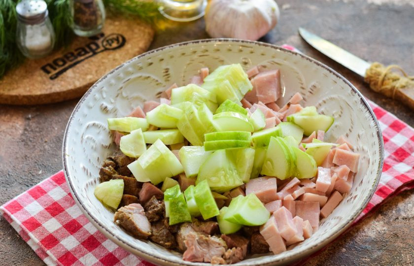 1. Этап. Салат с говядиной и ветчиной: Свежий огурец ополосните и просушите, нарежьте небольшими кусочками и добавьте в салат.