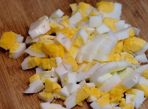 1. Этап. Салат с копченой курицей и кукурузой: Для начала сварим яйца. Для этого кладем их в холодную воду и доводим до кипения. Насыпаем немного соли, чтобы они не трескались. Через 10 минут достаем их и заливаем холодной водой, чтобы чистились лучше. Охлажденные яйца режем кубиками.