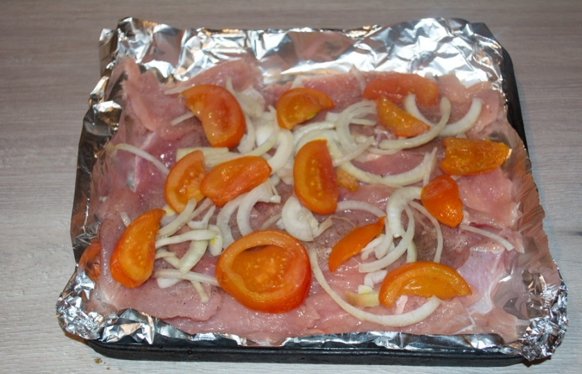 1. Этап. Мясо по-французски из куриного филе: Репчатый лук нужно нарезать полукольцами. Замариновать в 2 ст. ложках 6% уксуса, добавив 1 ст. ложку сахара. Оставить мариноваться на 20 минут. Лук промыть под проточной водой. Выложить на мясо. Нарезать помидоры. Выложить их сверху.