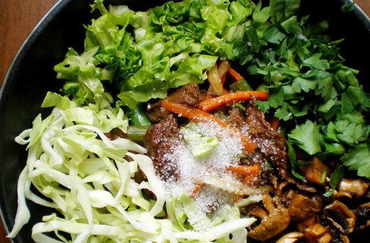 1. Этап. Лапша удон с говядиной: 2. Мясо вынимаем из маринада, и на прогретой сковороде обжарим вместе с измельченными луком и морковью. Затем добавим зелень, капусту, оставшиеся грибы вместе с маринадом. Добавим щепотку сахара и 100 мл воды. Тушим до готовности.