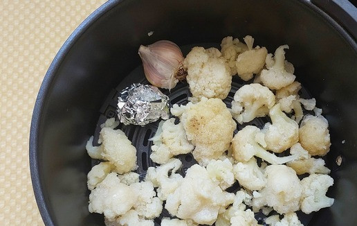 1. Этап. Цветная капуста с петрушкой и чесноком: Готовить будем в аэрогриле. Для этого слегка размороженную цветную капусту выкладываем на решетку аэрогриля, головку чеснока помещаем рядом, пасту из чесночных стрелок нужно предварительно завернуть в фольгу. Запекать при Т 180° 15 минут или до желаемого колера. Если готовить из свежей цветной капусты, то предварительно нужно с кочана срезать соцветия и пробланшировать их до состояния альденте.