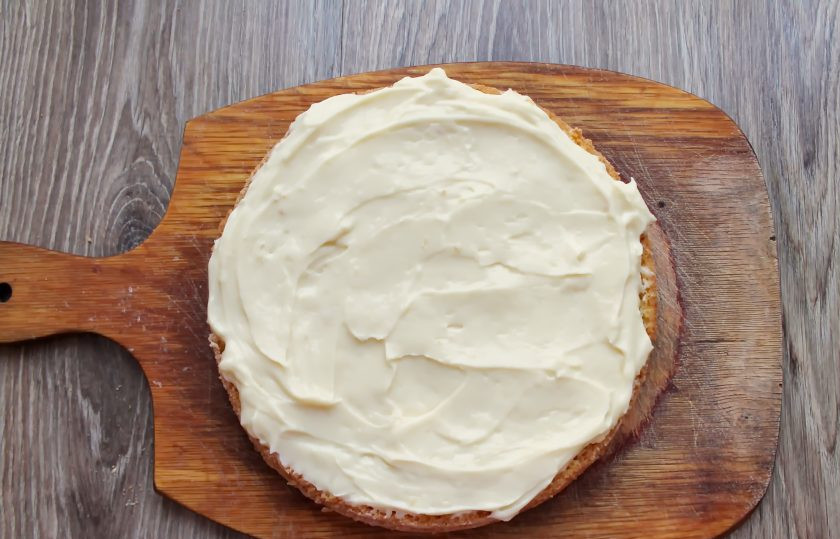 1. Этап. Торт Чародейка в мультиварке: На нижний корж выложите крем, оставив немного, и разровняйте.