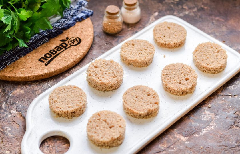 1. Этап. Канапе с килькой и яйцом: При помощи формочки вырежьте из хлеба заготовки для канапе.