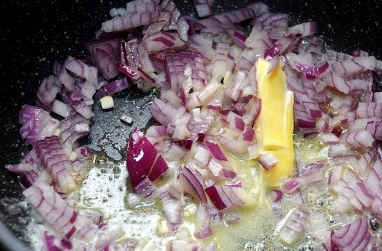 1. Этап. Паста с белыми грибами: Спассеруйте лук в смеси растительного и сливочного масел на среднем огне.