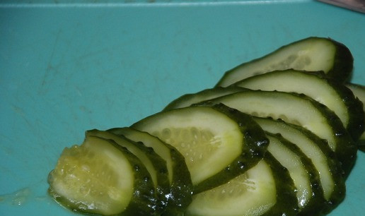 1. Этап. Теплый салат с мясными шариками: Нарезать тонкими слайсами наискосок маринованные огурцы.