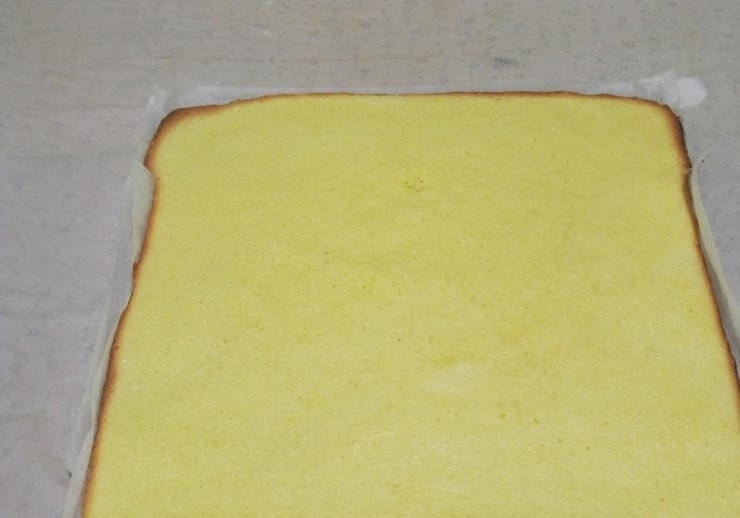 1. Этап. Рулет с вареной сгущенкой: 6. Выпекаем бисквит в духовом шкафу при температуре 200 градусов около двадцати минут. После приготовления перекладываем готовый бисквит вместе с пергаментом на полотенце.