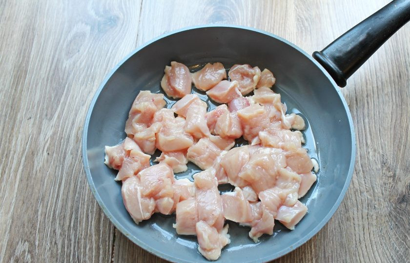 1. Этап. Куриное филе с черносливом: Куриное филе сполосните и обсушите. Порежьте филе средним кубиком. В сковороду налейте растительное масло, разогрейте и выложите кусочки курицы.