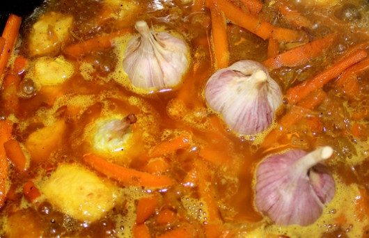 1. Этап. Плов с куриным филе: Далее вливаем кипяток, так чтобы он был выше уровня овощей на 2-3 см. Хорошенько солим, в середину кладем головки чеснока и целый острый перчик. Накрываем казан крышкой и тушим все минут 30-40 на медленном огне.