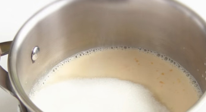 1. Этап. Торт-безе с масляным кремом: 7. Готовим крем. В кастрюле смешайте желток с молоком, добавьте сахар и варите на медленном огне до загустения, постоянно помешивая.