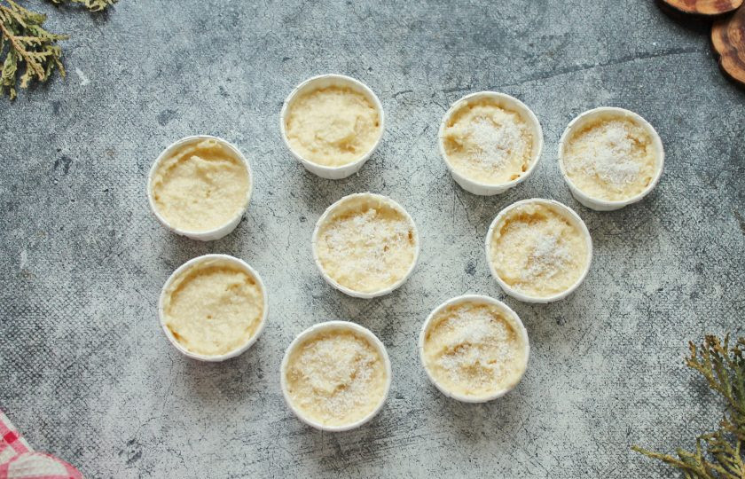 1. Этап. Маффины с кокосовой стружкой: Разложите тесто по бумажным капсулам на 2/3 высоты и посыпьте кокосовой стружкой. Установите их на противень и поставьте в горячую духовку.