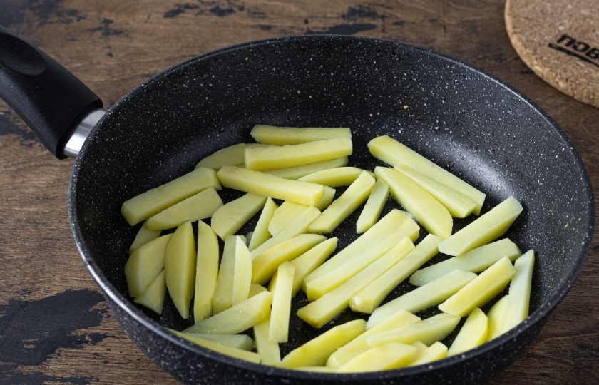 1. Этап. Жареная картошка с папоротником: Картофель очистите и нарежьте соломкой. Обжарьте картофель с одной стороны до золотистого цвета.