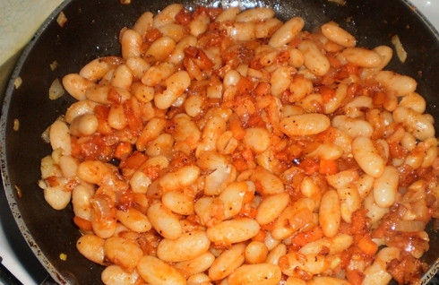 1. Этап. Тушеная фасоль с луком и морковью: Сваренную фасоль процедим и добавим на сковороду к овощам. Посолим, поперчим, добавим соус и немного воды. Количество воды зависит только от вас: хотите побольше подливки — значит и воды добавите чуть больше. И не забывайте пробовать блюдо на соль. Перемешиваем и тушим все вместе еще минут 10. А теперь можно добавить измельченной зелени и подать блюдо к столу.