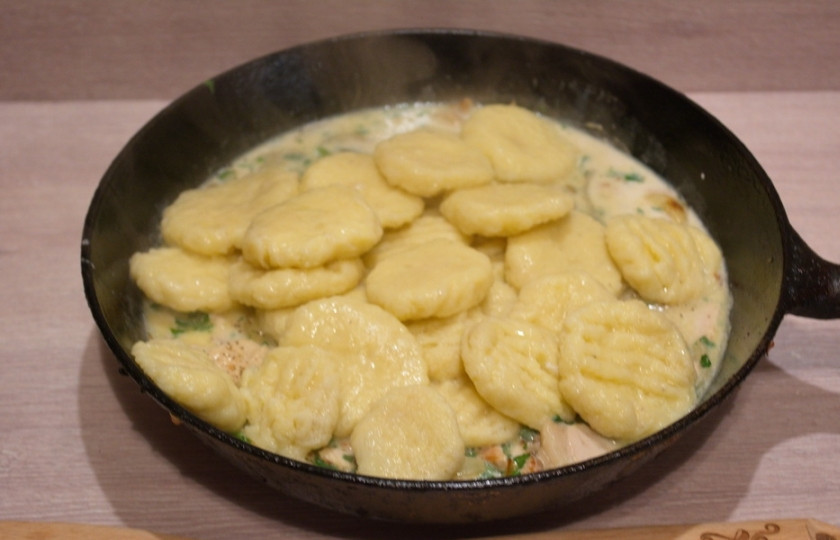 1. Этап. Ньокки с мясным соусом: 12. Включите огонь под соусом. Из кипящей воды извлеките готовые ньокки. Поместите их в сковороду к соусу. Перемешайте.