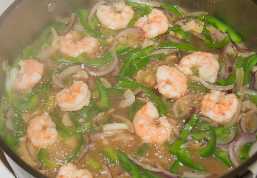 1. Этап. Стеклянная вермишель с креветками и соусом: Разогрейте в сковороде растительное масло, обжарьте на нем чеснок (пару минут). После этого добавьте овощи и влейте воду с соевым соусом. Доведите до кипения, выложите вермишель и тушите еще пару минут. Выключите огонь.