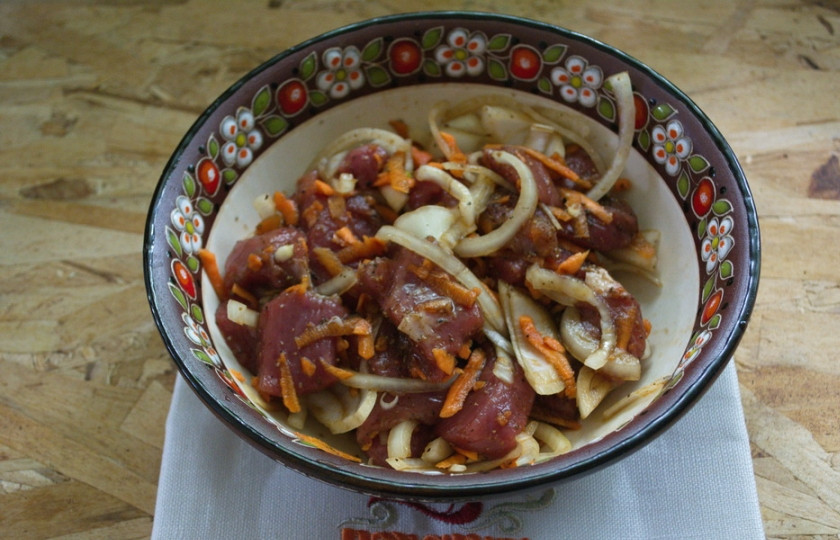 1. Этап. Мясо с овощами в горшочках: К мясу добавьте соль, специи, 2-3 ст. ложки растительного масла, морковь и нарезанный лук. Перемешайте.